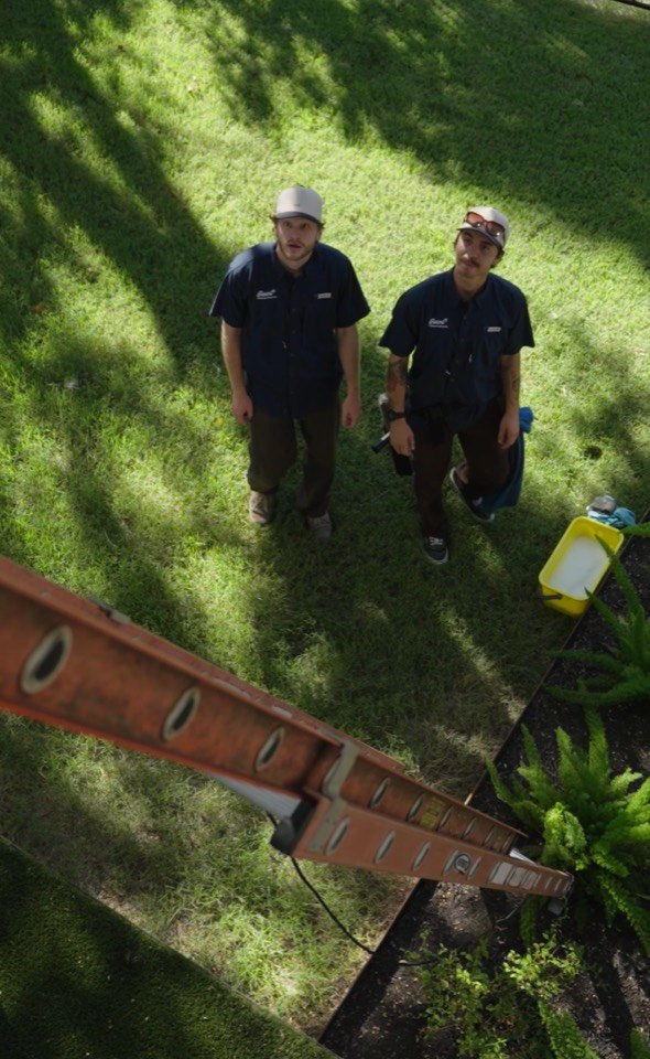 Two Giant Window Cleaning crew members checking ladder access at a residential job